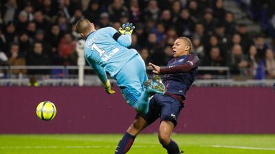 Lyon's goalkeeper Anthony Lopes, left, collides with PSG's Kylian Mbappe as they challenge for the ball during their League 1 match. Laurent Cipriani / AP Photo