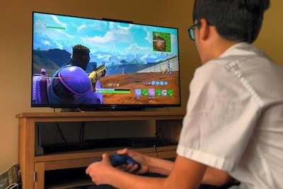 A teenage boy plays the hit computer game Fortnite. Epic Games banked US$296m (Dh1.08 billion) in April alone as a result of Fortnite players converting their (and their parents’) hard-earned cash to the in-game currency, V-Bucks