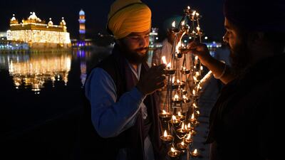 Sikh devotees light lamps on the anniversary of the birth of Guru Arjan Dev at the Golden Temple, Amritsar. AFP