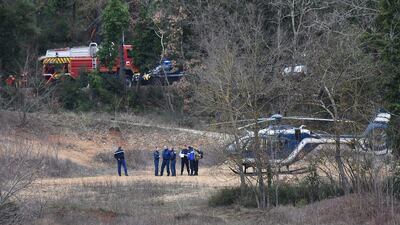 French gendarmes, right, and firefighters work at the site of the accident. Anne-Christine Poujoulat / AFP