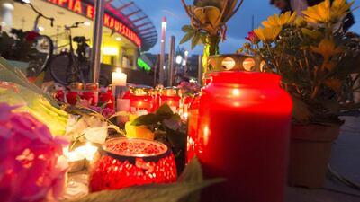 People gather to read tributes among the flowers and candles near the Olympia shopping centre in Munich where David Ali Sonboly killed nine people. Jens Meyer/AP Photo