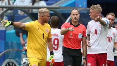 Denmark's Kasper Schmeichel and Simon Kjaer protest to referee Antonio Mateu Lahoz after he awarded a penalty to Australia following a VAR referral. Pilar Olivares / Reuters