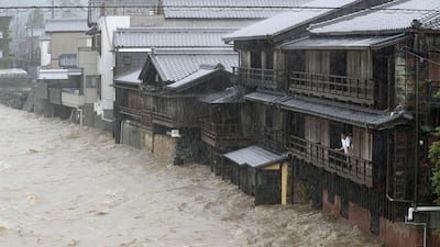 Men watch the swollen Isuzu River due to heavy rain caused by Typhoon Hagibis in Ise, central Japan. Reuters