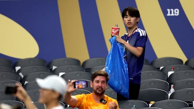 Japan fans clean up at the Dallas Stadium. AFP