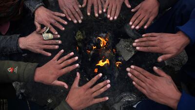 People sit around a fire to warm themselves after a heavy snowfall in Kabul, Afghanistan. AP Photo