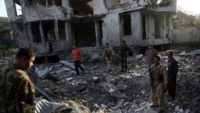 Afghan security personnel assess the damage caused by the attack that apparently targeted the country's acting defence minister.