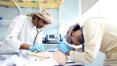 Trainees Ahmed al Hammadi, left, and Abdulla al Zhami practise a life-saving procedure on a mannequin of a baby.