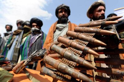 Former Taliban fighters display their weapons in Herat province on May 2, 2012. AFP