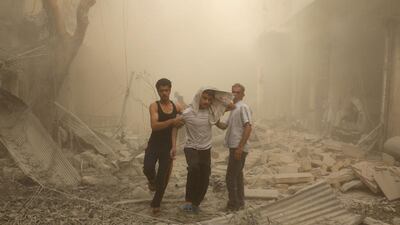 Syrians help a wounded youth following an air raid on the Fardous rebel held neighbourhood of Aleppo. Ameer AlHalbi / AFP Photo