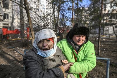 A woman is evacuated from a burning apartment building in Kyiv after strikes on residential areas. AFP
