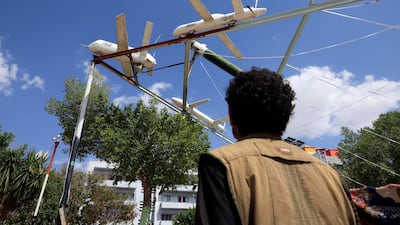 A person passes by a display of Houthi-made mock drones and missiles at a square in Sana'a, Yemen. EPA