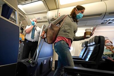 A passenger wears a mask while boarding a United Airlines flight at George Bush Intercontinental Airport last Sunday. AP Photo