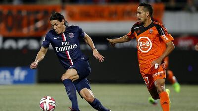 Paris St Germain's Edinson Cavani, left, fights for the ball with Lorient's Walid Mesloub during their French Ligue 1 match at the Moustoir stadium in Lorient November 1, 2014. Stephane Mahe / Reuters