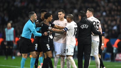 PSG's Marquinhos and Ashley Young of United clash.
