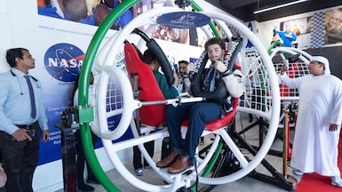 People try the astronaut-training simulator at the relaunch of the Space and Rocketry Academy in Dubai. Ruel Pableo / The National