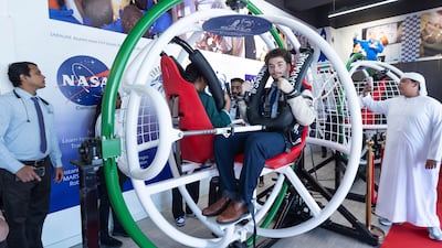 People try the astronaut-training simulator at the relaunch of the Space and Rocketry Academy in Dubai. Ruel Pableo / The National