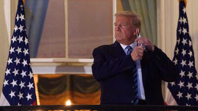 US President Donald Trump takes off his face mask at the White House. Global shares plummeted after President Trump scrapped negotiations over Covid-19 economic relief funding until after the presidential election on November 3. AFP