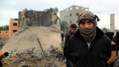 A Palestinian man looks on as he stands in front of a building that was destroyed by an Israeli air strike, in Khan Younis. Reuters