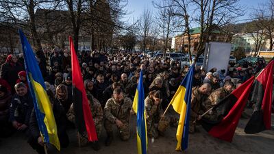 Ukrainian servicemen kneel during the funeral ceremony of killed comrades Vasyl Medviychuk and Dmytro Dosiak in Verkhovyna, on December 28. AP