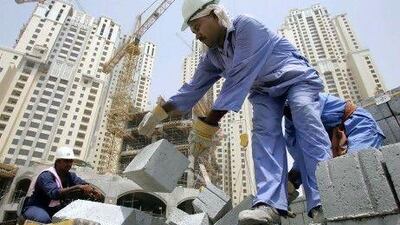 A worker unloads cement blocks from a truck at a construction site in Dubai. REUTERS / Devadasan