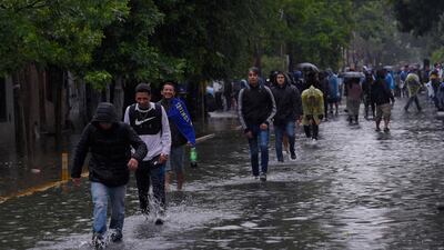 Fans make their way through flooded streets towards the stadium. AP Photo
