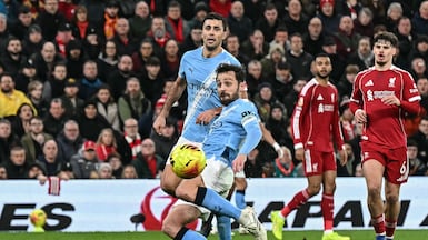 Manchester City's Portuguese midfielder #20 Bernardo Silva (front L) shoots to score his team's first goal to equalise during the English Premier League football match between Liverpool and Manchester City at Anfield in Liverpool, north west England on February 8, 2026. (Photo by Paul ELLIS / AFP) / RESTRICTED TO EDITORIAL USE. No use with unauthorized audio, video, data, fixture lists, club/league logos or 'live' services. Online in-match use limited to 120 images. An additional 40 images may be used in extra time. No video emulation. Social media in-match use limited to 120 images. An additional 40 images may be used in extra time. No use in betting publications, games or single club/league/player publications. /