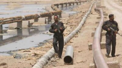 Iraqi police officers protect an oil pipeline in the Rumailah refinery, north of Basra, Iraq's second-largest city.