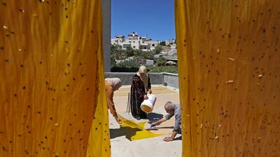 Palestinian Abed Al Lattif Karaje and his wife Nabeeha prepare traditional Malban sweets made from grape juice in Halhul near Hebron city, in the occupied West Bank.