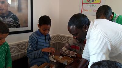 Akon helps Majid assemble one of Beacon of Hope’s light kits which will allow the Moroccon orphan to work on homework and read at night. Naser Al Wasmi / The National