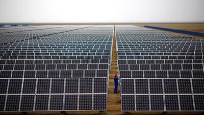 A worker inspects solar panels at a solar farm in Dunhuang, Gansu Province, China. Reuters