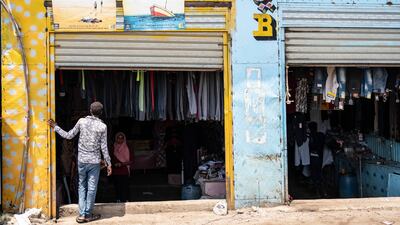 An Eritrean youth peers into a clothes shop in the market at Shagarab refugee camp, which hosts more than 60,000 people, in Sudan. On its walls are signs from the UN warning residents about the dangers of following migration routes through deserts and across seas. Getty