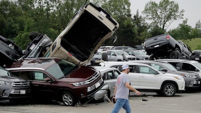 A worker walks past tornado-damaged Toyotas at a car dealership in Jefferson City. AP Photo