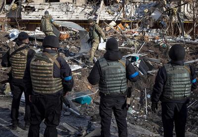 Ukrainian soldiers inspect the rubble of a destroyed apartment building in Kyiv. AFP