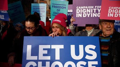 Campaigners supporting the assisted suicide bill hold placards at a demonstration outside The Palace of Westminster. AFP