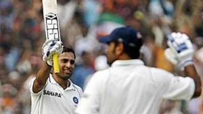 VVS Laxman acknowledges the Eden Gardens ground after reaching his century. Dhoni, right, reached his too soon after.