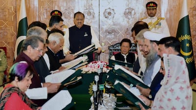 Prime Minister Imran Khan, centre right, looks on as the 21-member cabinet is sworn in. Press information department via AP