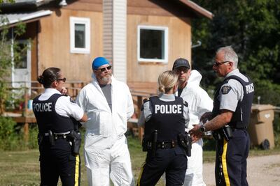 Forensics officials and police officers gather outside a crime scene where stabbing victim Wes Petterson was found, in Weldon, Saskatchewan, on Wednesday. AFP