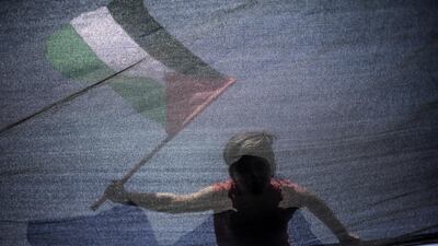 A boy waves the Palestinian flag from a fishing boat carrying a group of activists during a protest against the Israeli siege imposed on Gaza Strip, west of Gaza city, on July 10, 2018. EPA