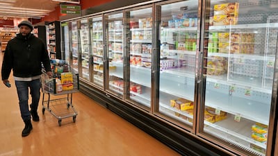 A customer walks past empty shelves at Heinen's Fine Foods store in Pepper Pike, Ohio. AP