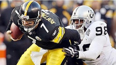 Pittsburgh Steelers' quarterback, Ben Roethlisberger, scrambles past the Oakland Raiders defensive end Jay Richardson.