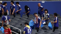 Japan fans clear trash in the stands after their World Cup match against the Netherlands at the Dallas Stadium in Arlington, Texas. AFP