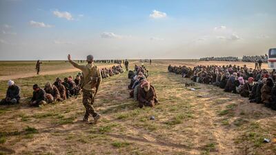Men suspected of being ISIS fighters wait to be searched by members of the Kurdish-led Syrian Democratic Forces (SDF) in Syria's northern Deir Ezzor province on February 22, 2019. AFP