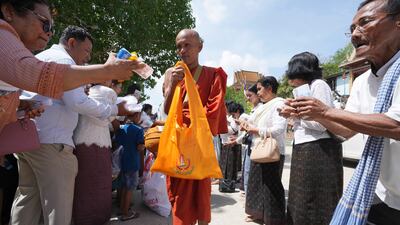 A Buddhist monk receives alms from devotees during the Buddhist Visak Bochea festival at Praseth Leu pagoda, north-west of Phnom Penh, Cambodia. AP