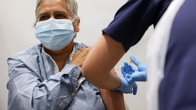 A person gets the coronavirus vaccine, at a vaccination centre in Westfield Stratford City shopping centre, in London, Britain. Reuters