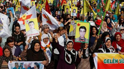 Kurdish and Arab protesters chant slogans against Turkish President Tayip Erdogan as they walk during a march to the United Nations Headquarters in the town of Qamishli, Syria. REUTERS