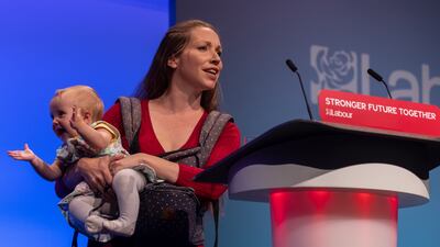 Catherine Atkinson, whose husband served in Afghanistan, holds nine-month-old Elena as she addresses delegates. Getty Images