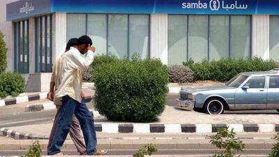 Pedestrians in Jeddah walk past a branch of the Saudi American Bank (SAMBA) in Jeddah, Saudi Arabia. AP Photo