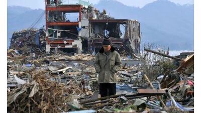 Jinji Kato stands amid debris in Miyagi Prefecture yesterday. The area was hit hard by the earthquake and tsunami that struck on Friday.
