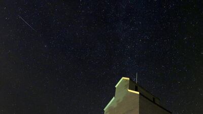 In this photo taken with long exposure, a meteor streaks across the sky behind a grain elevator in Baxter, Iowa. Charlie Riedel / AP Photo