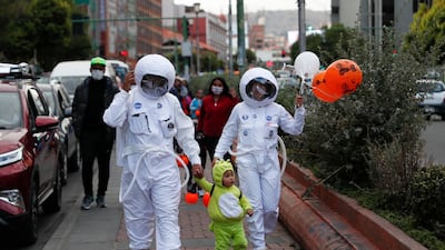 People wearing NASA astronaut costumes trick-or-treat with a child dressed as an alien on Halloween in La Paz, Bolivia. AP Photo